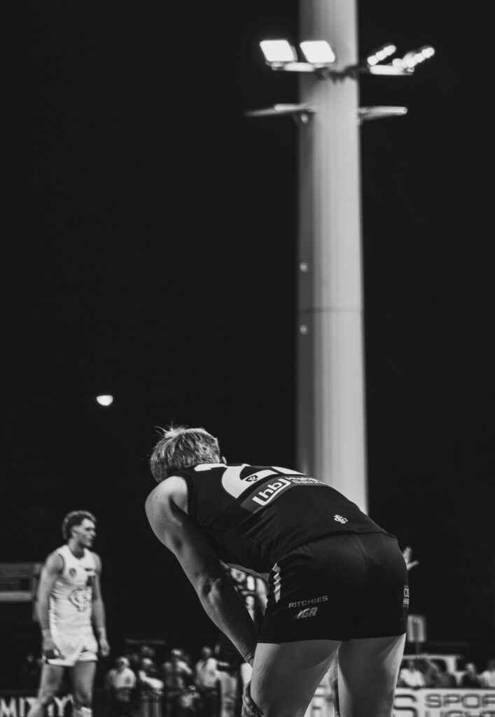 Sportiv profesionist aplecat pe teren în timpul unei competiții desfășurate sub nocturnă